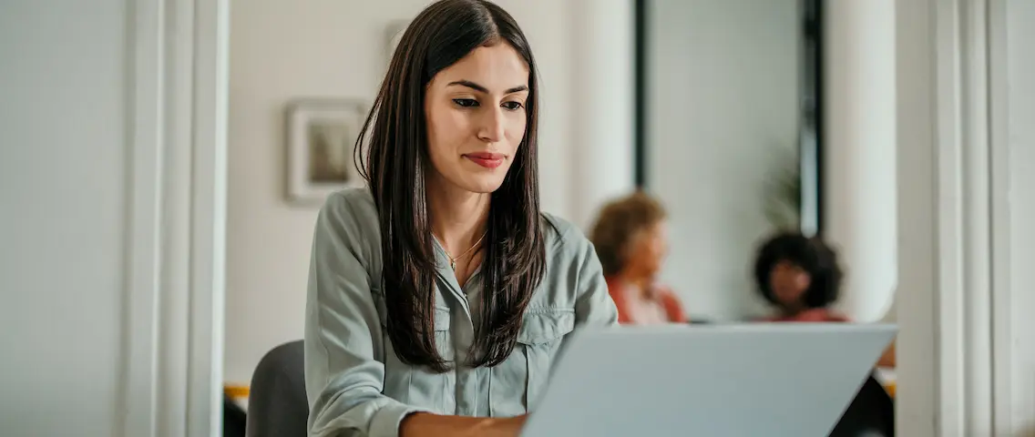 Kvinna arbetar vid en laptop på kontoret