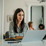 Kvinna arbetar vid en laptop på kontoret