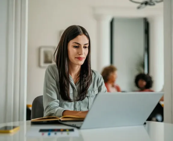 Kvinna arbetar vid en laptop på kontoret