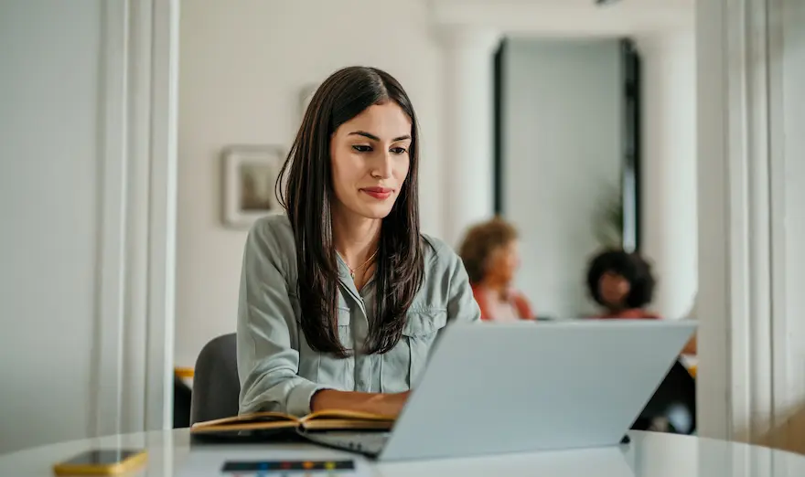 Kvinna arbetar vid en laptop på kontoret
